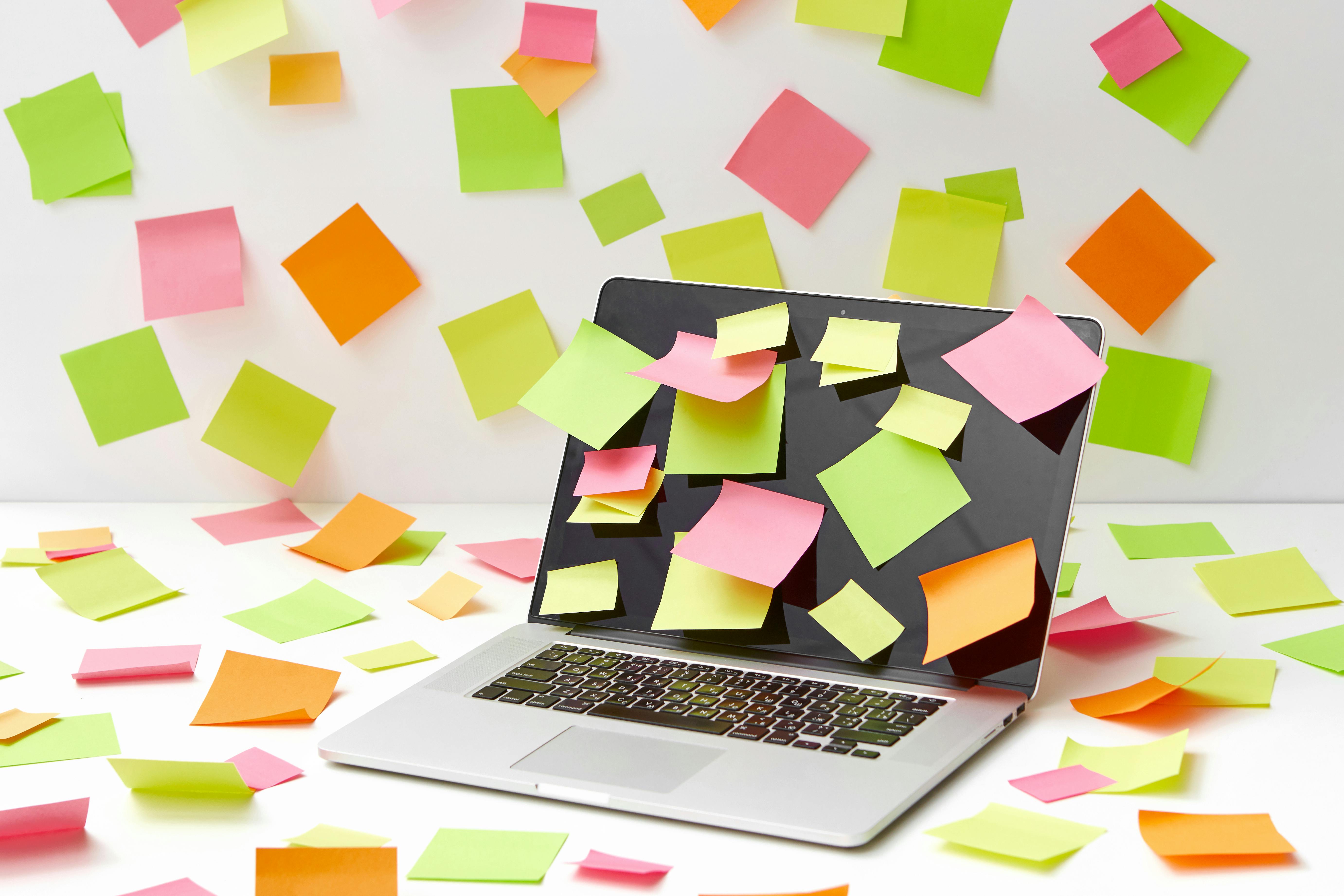 Sticky notes covering laptop and desk
